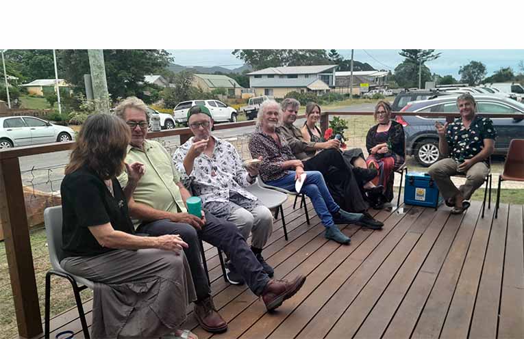 Attendees relaxing in conversation on the verandah.
