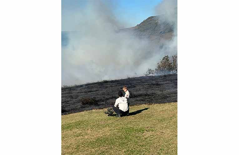 Yurruungga Aboriginal Corporation ranger Brentyn Lugnan with Junior Ranger Asher Kelly, 5. PHOTO2: The first demonstrated cultural burn at a Crown reserve managed by Reflections Holidays.