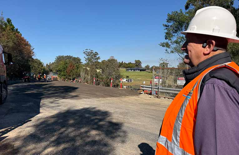 Nambucca Valley Mayor Gary Lee watching the spray-sealing of Flame Tree Road, Valla, on Friday 7 August. This is the last major construction task required to finish the landslip remediation job, funded by the Disaster Recovery Funding Arrangements.